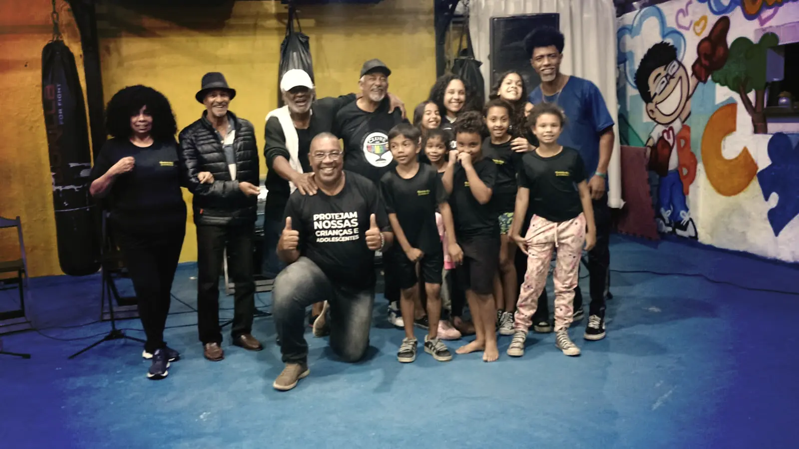 Grupo de crianças e organizadores posando para registro em foto.