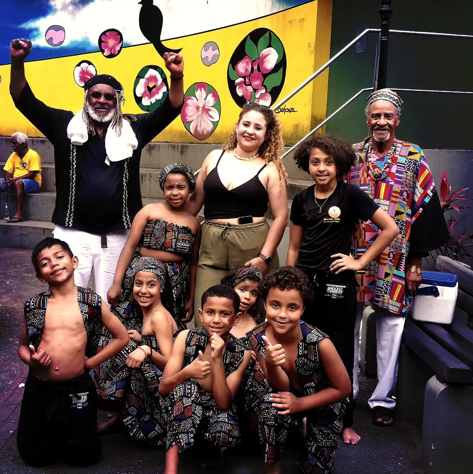 Artistas e crianças celebrando uma apresentação.